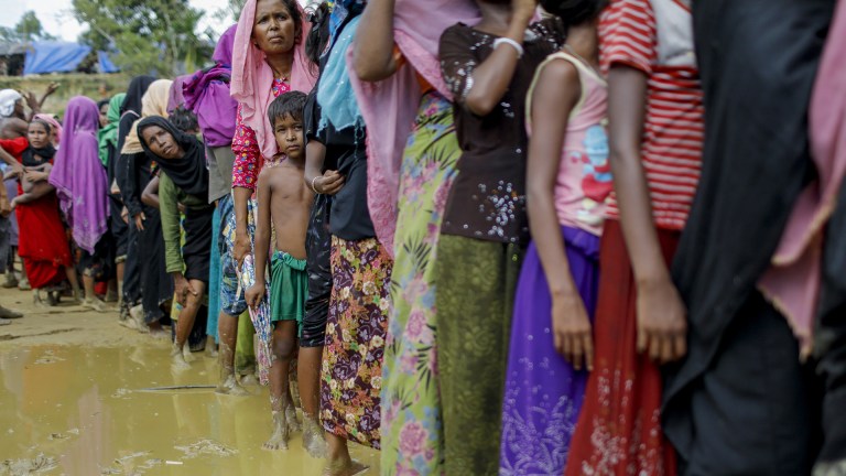 Rohingya refugees wait in line for food