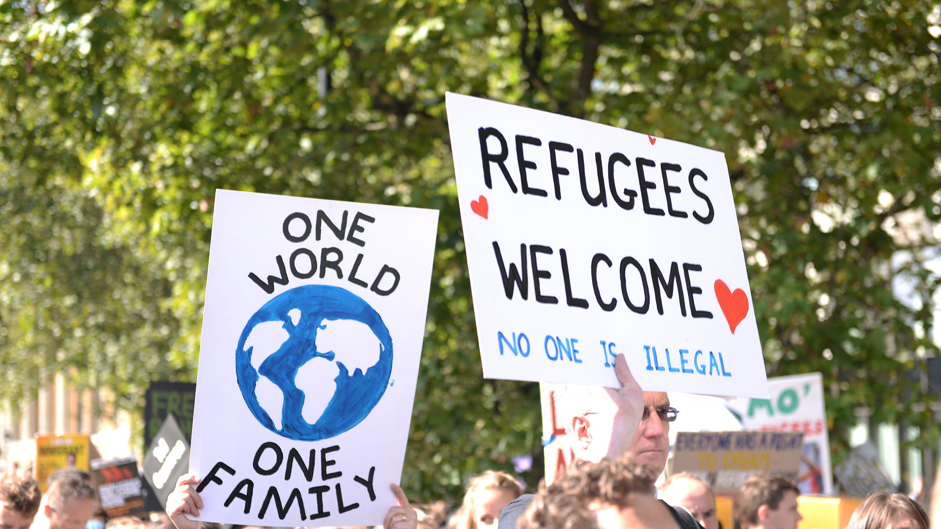 placards reading "refugees welcome"