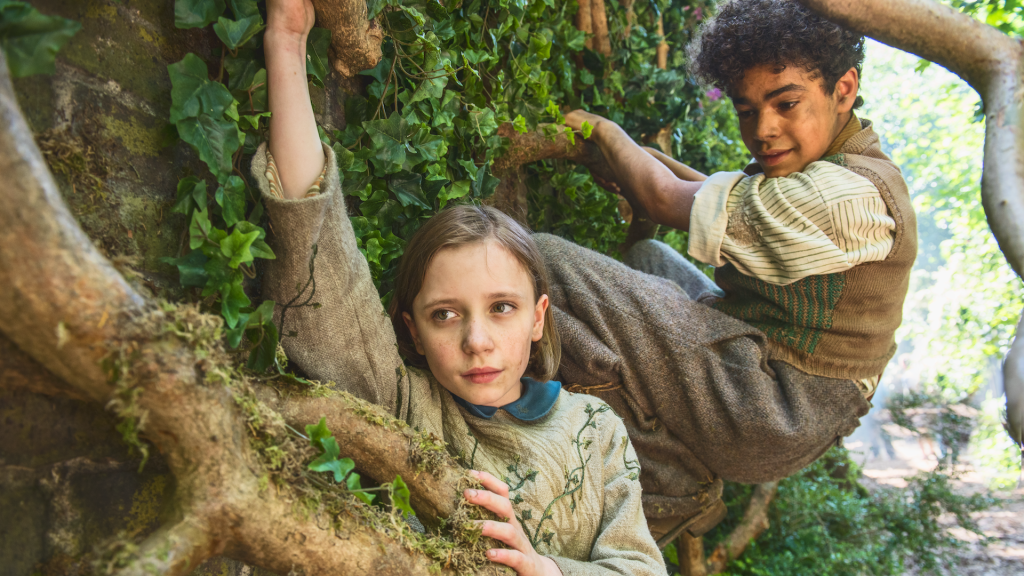 Dixie Egerickx and co star Amir Wilson climb vines in The Secret Garden