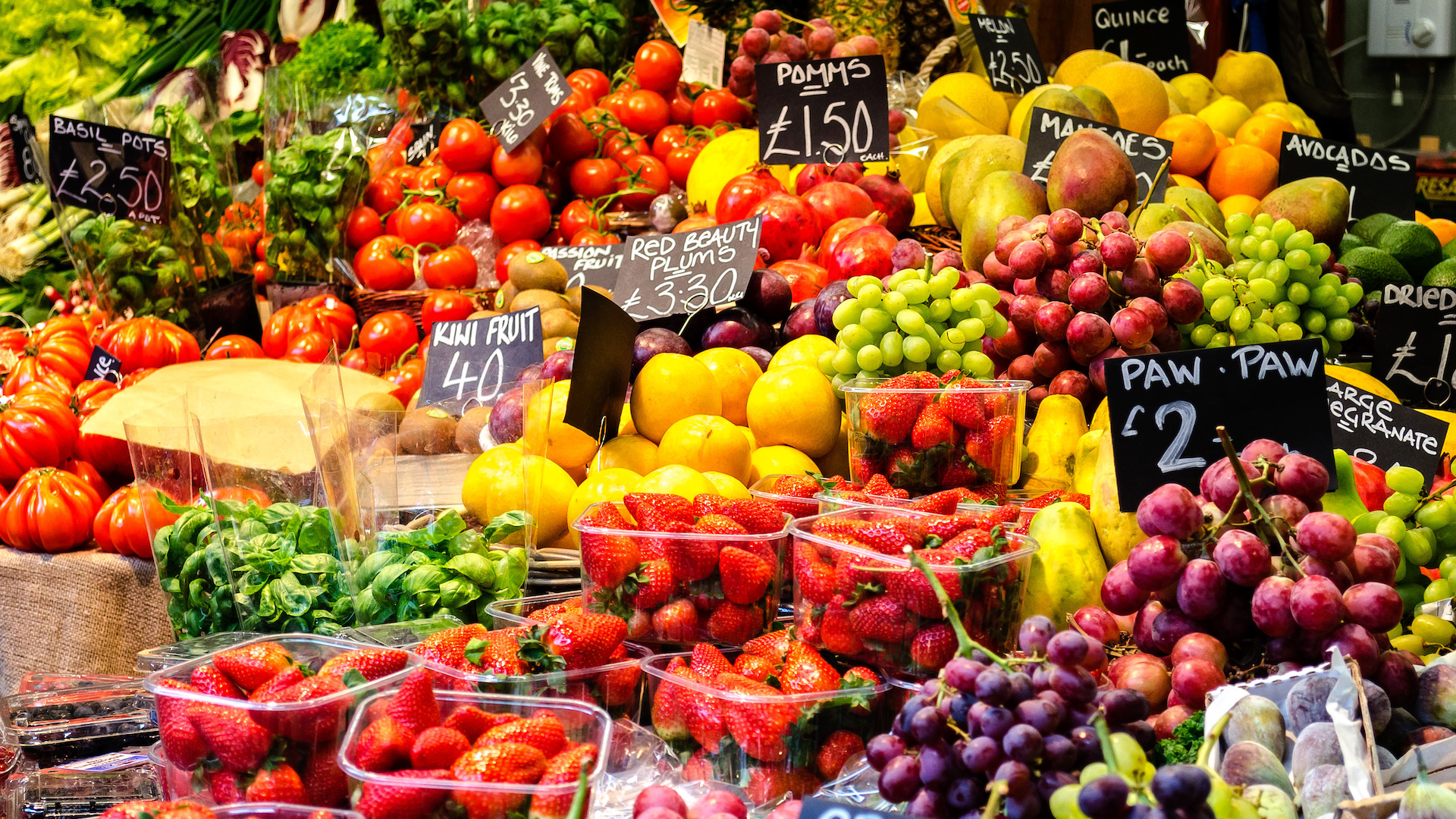 Fruit and vegetable of all colours pile high at a market stand