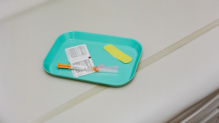 Vaccine on a tray with swabs and a band-aid