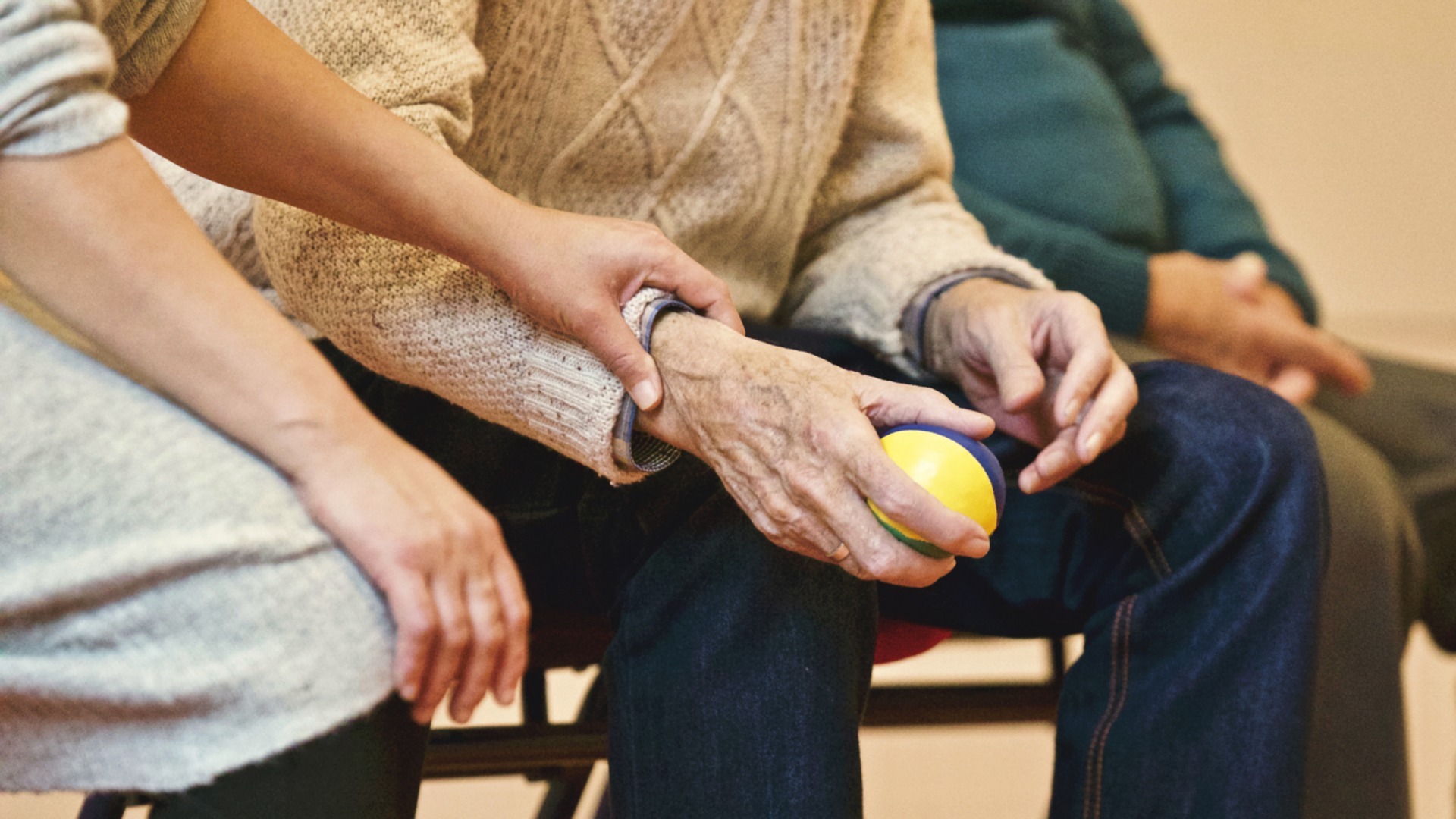 Woman's hand on an elderly person's arm. The Universal Credit increase must be kept to support those in low-paid jobs