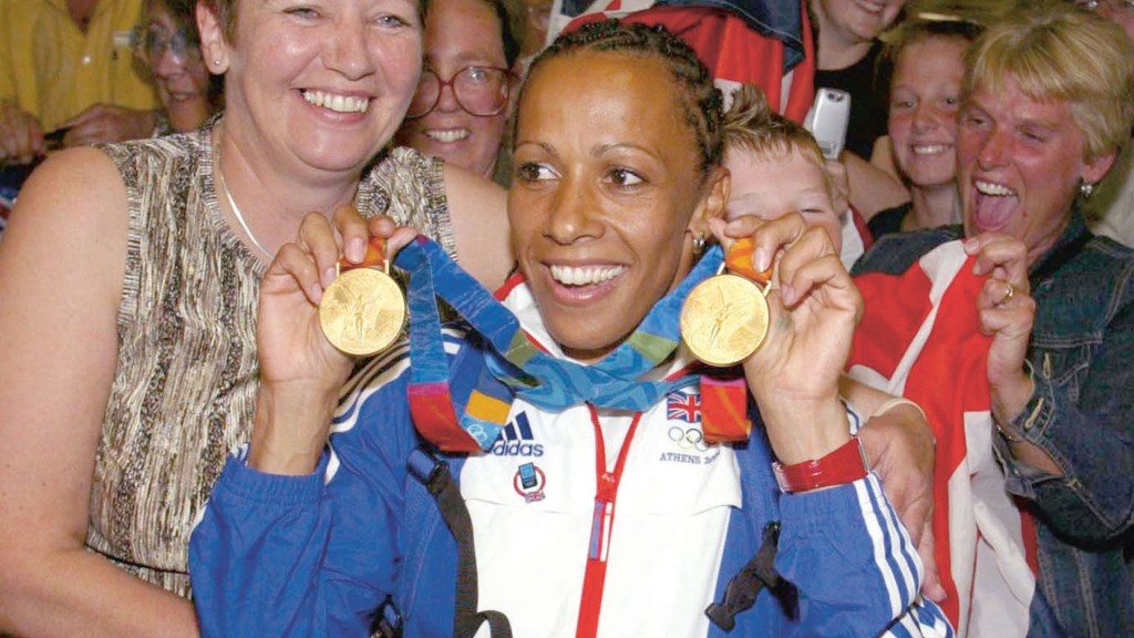 Dame Kelly Holmes with her mum Pam after arriving back from the Athens Olympics in 2004. Image credit: Shutterstock