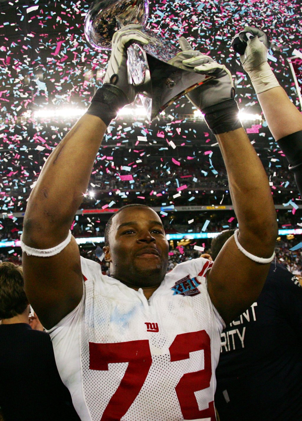 Two-time Super Bowl winner Osi Umenyiora of the New York Giants lifts the trophy after defeating the New England Patriots 17-14 in Super Bowl XLII on February 3, 2008. Image credit: Harry How/Getty Images