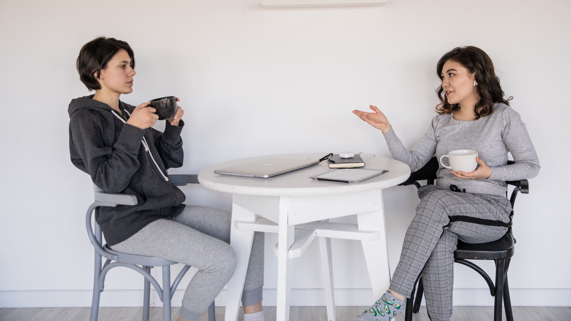 Two women sit talking at a table