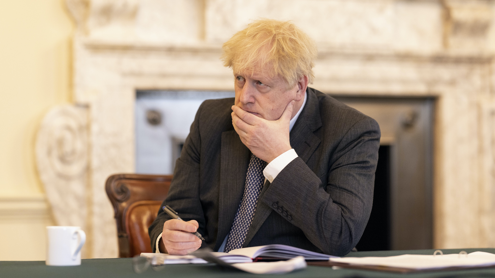 Boris Johnson looks serious at a table in Downing Street