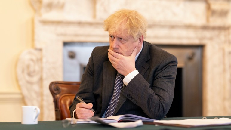 Boris Johnson looks serious at a table in Downing Street