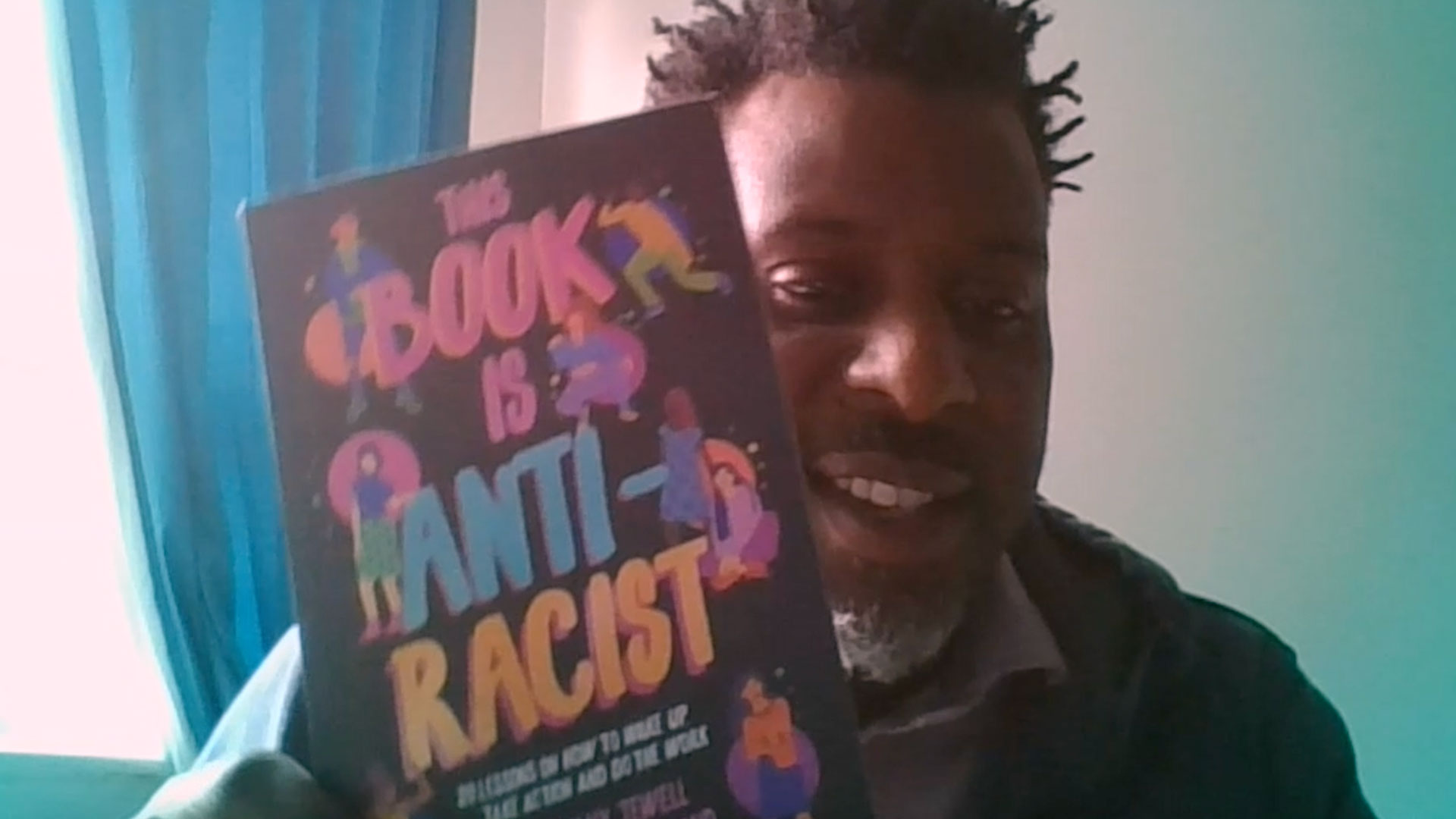 Stuart Lawrence holding one of his recommended books about racism