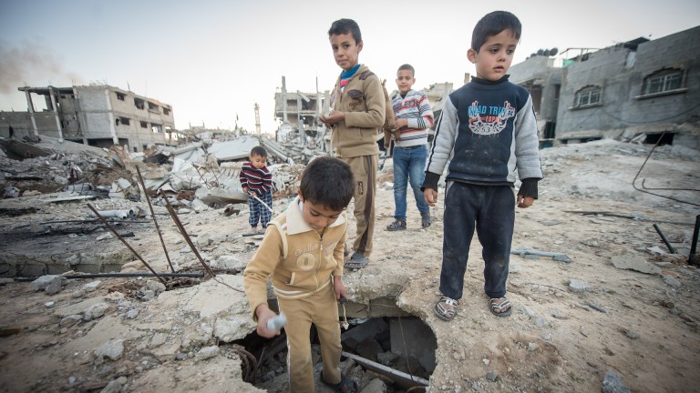 Children survey the ruins in Khuzaa, Gaza, in 2015.