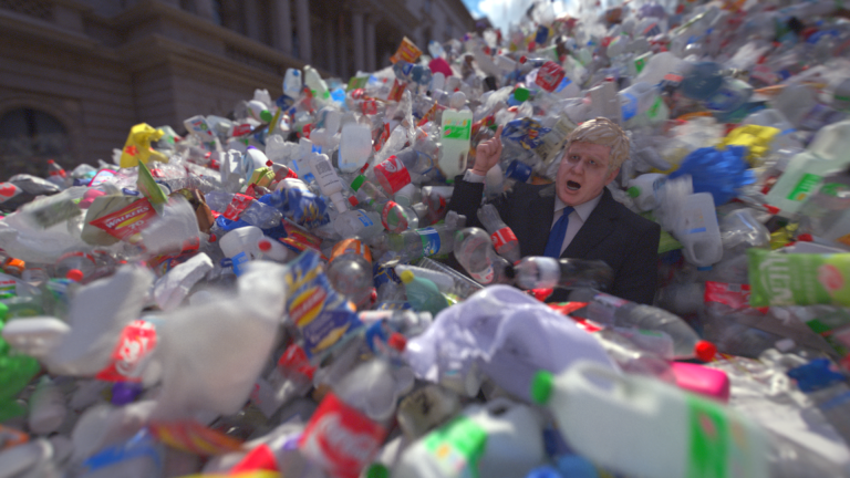 Wasteminster is the launch film for Greenpeace's 2021 campaign against the UK's waste exports to other countries. Voiced by impressionists Matt Forde and Jon Culshaw, the film features Boris Johnson being engulfed in a wave of plastic while giving a speech in Downing Street. Producers Park Village and Studio Birthplace used a bespoke VFX simulation to create the dynamic flow of 1.8 million kilos of plastic - the amount of waste the UK exports to other countries every day. Image credit: Greenpeace