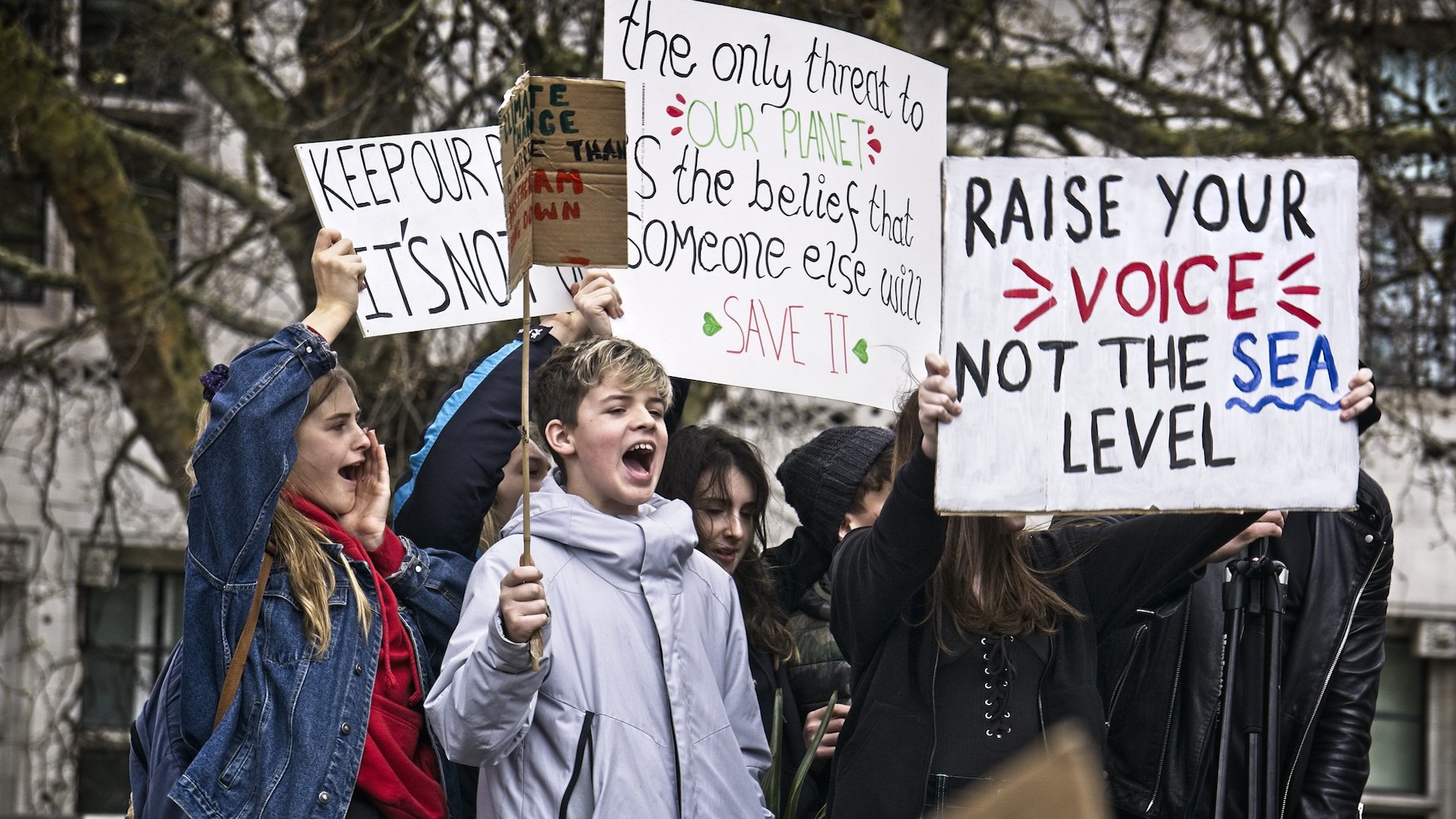 School pupils hold signs on London streets to protest the climate crisis