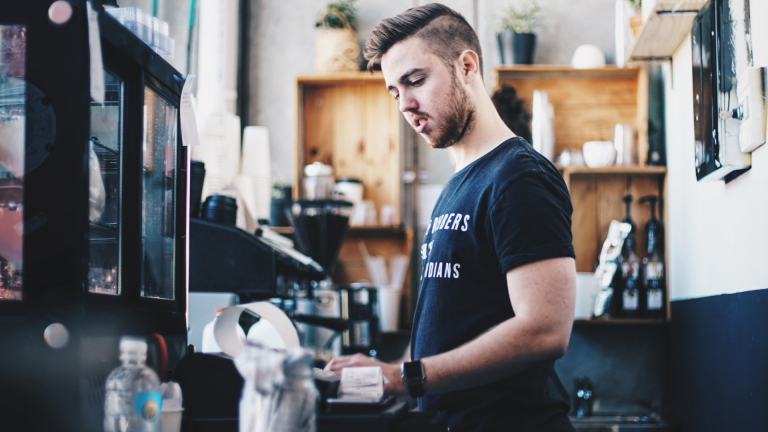 Cafe worker totals up a till at the end of the day