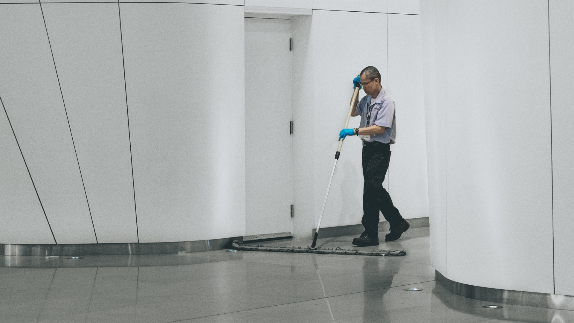 Cleaner sweeps the floor inside an office building