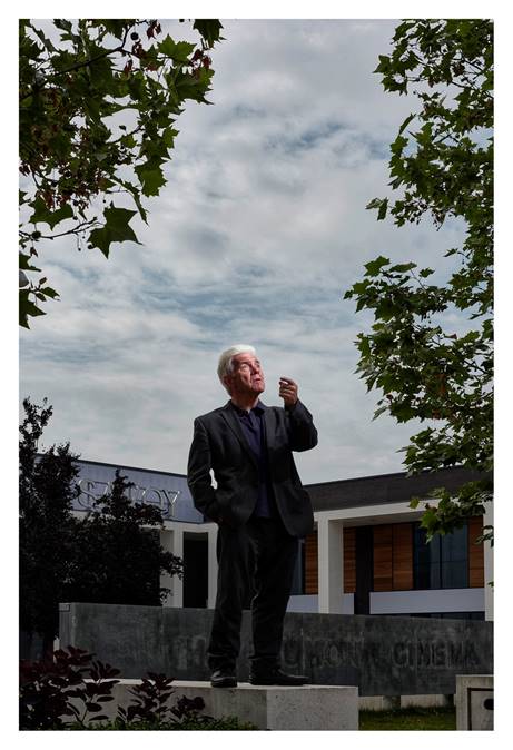 Ian McMillan stands on a pedestal looking up at the sky