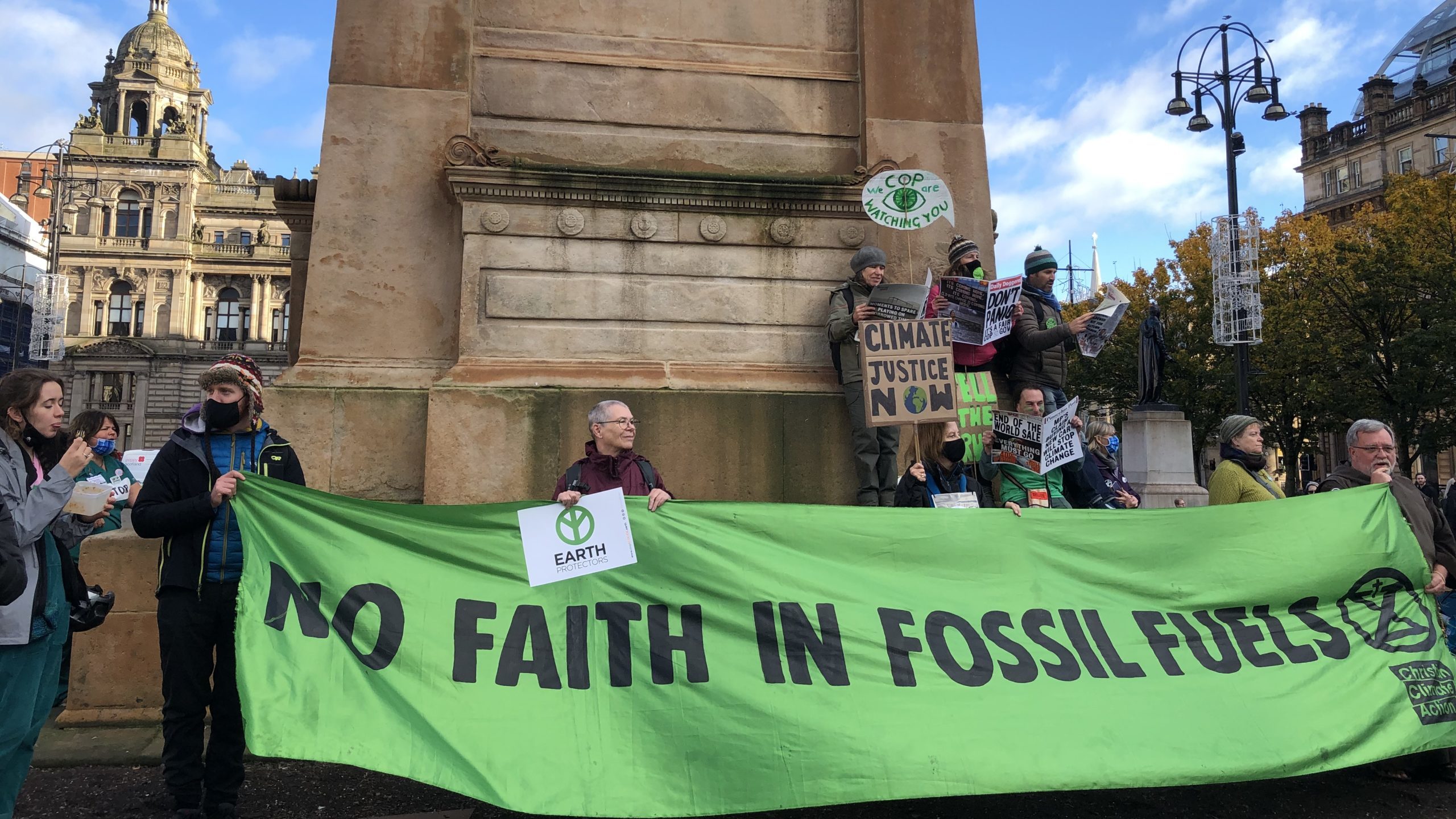 Protesters holding a banner that reads: "No faith in fossil fuels"