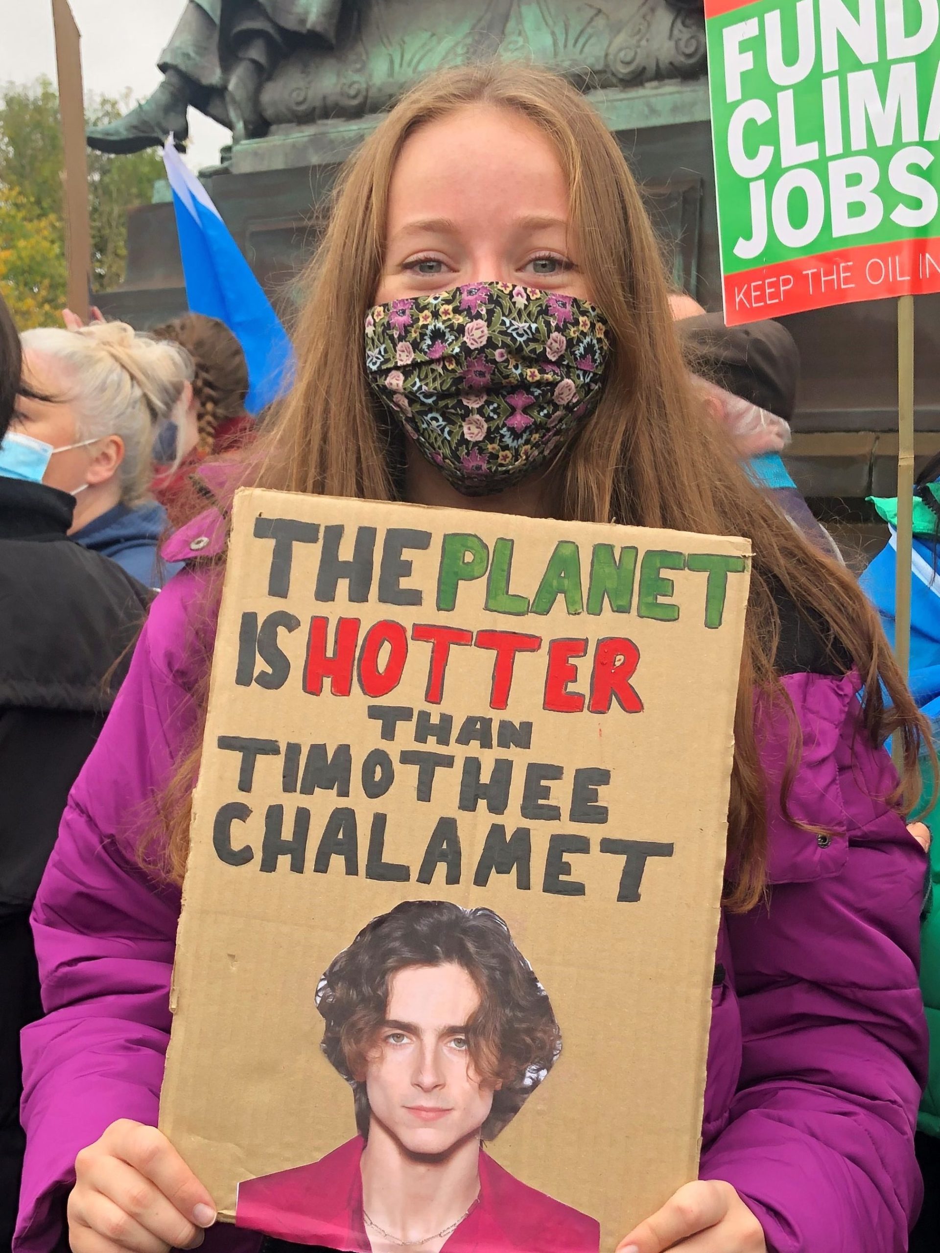 A protester with a sign stating that "the planet is hotter than Timothée Chalamet. Image: Sarah Wilson