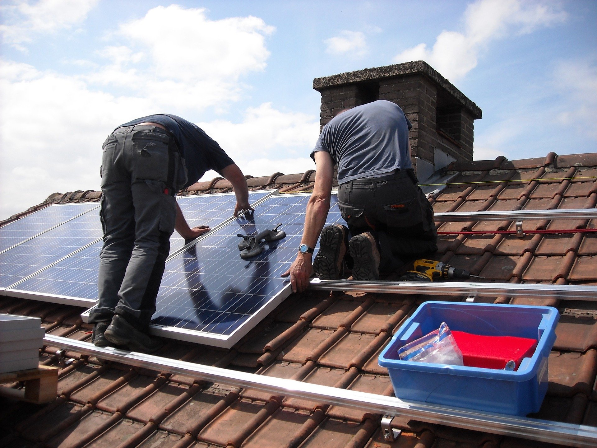 Two men fitting solar panels.