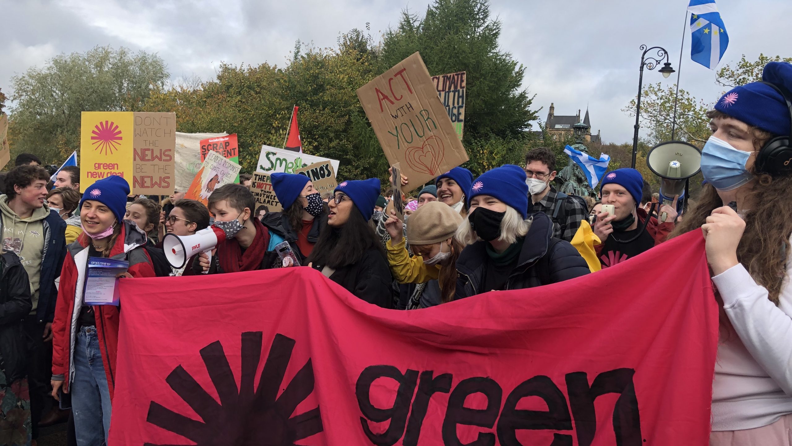 Protesters at a climate march holding a Green New Deal banner