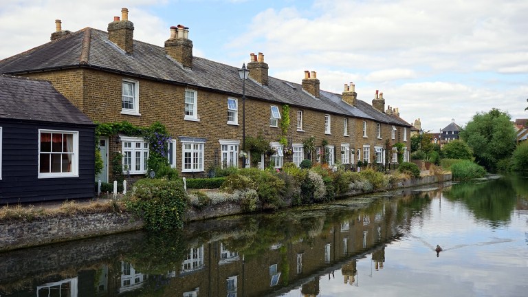 A row of terraced homes by a river.