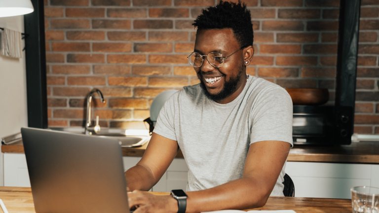 A man works at a laptop in a kitchen