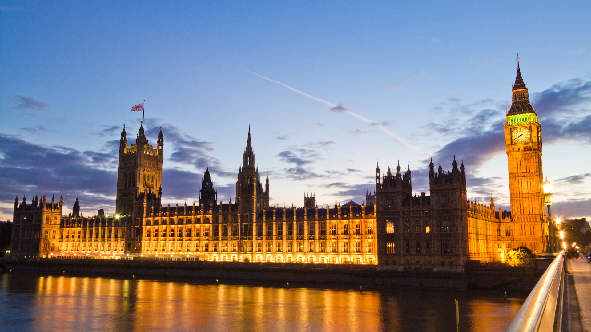 The Palace of Westminster lit up at night, reflected in the Thames