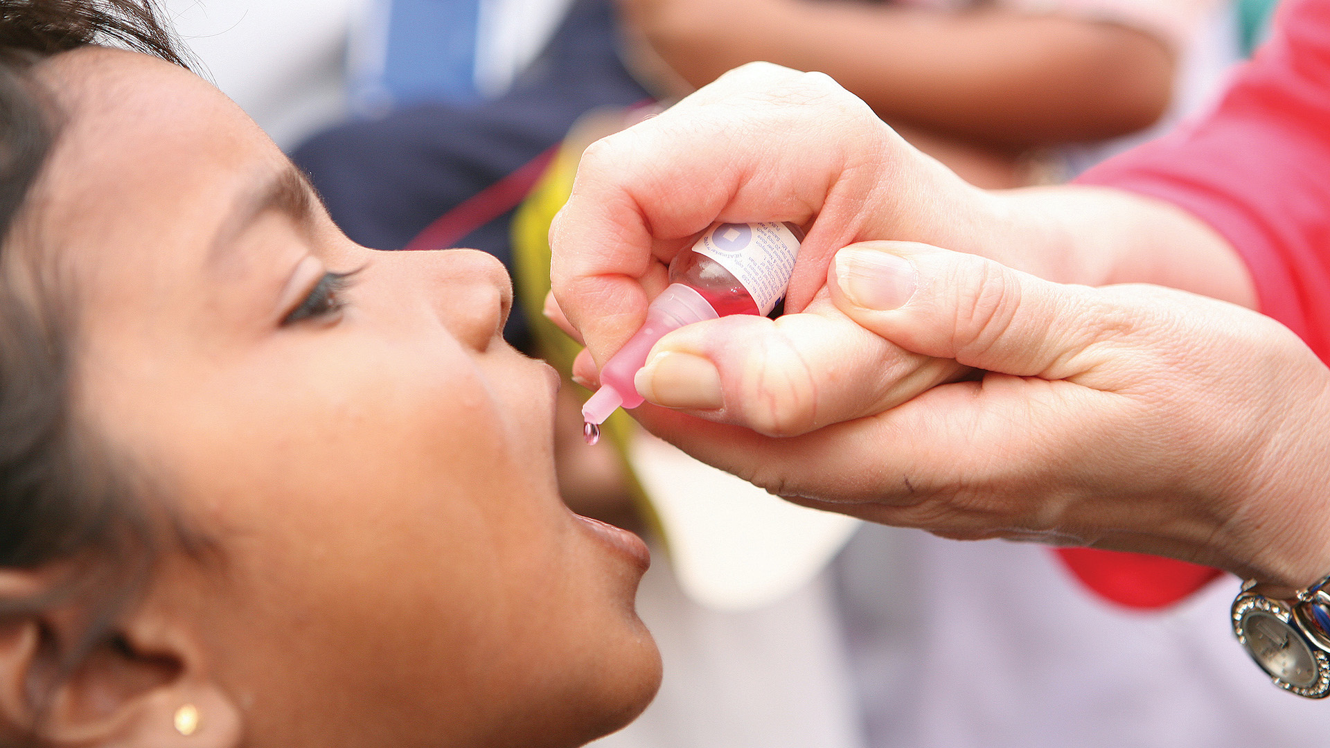 A young boy receives a drop of the polio vaccine