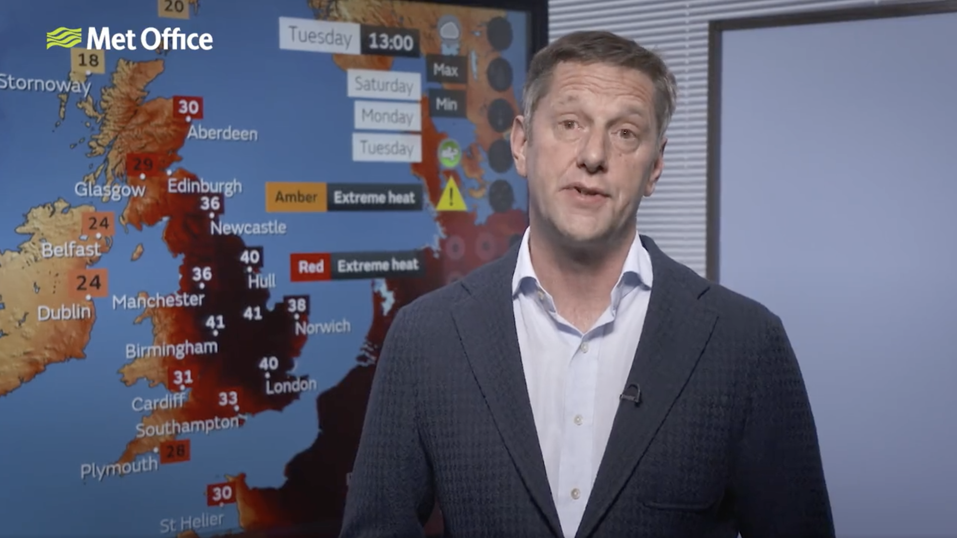 Met Office chief scientist Stephen Belcher wears a white shirt and grey cardigan in front of a map showing record temperatures of 40C across the UK