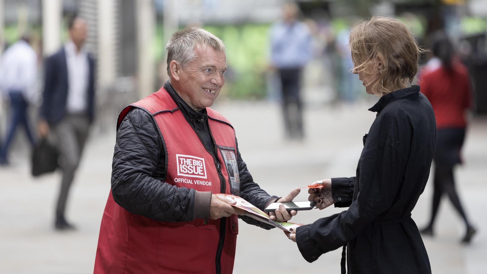 Big Issue vendor Hugh Palmer makes a cashless sale