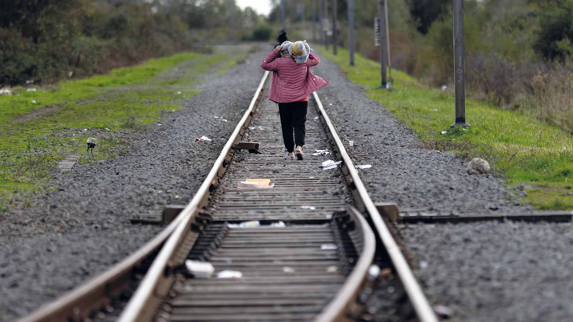 A refugee carries her child back to a tent after visiting a distribution point run by the refugee crisis charity Care4Calais on November 02, 2022 in Dunkerque, France. Photo: Christopher Furlong/Getty Images