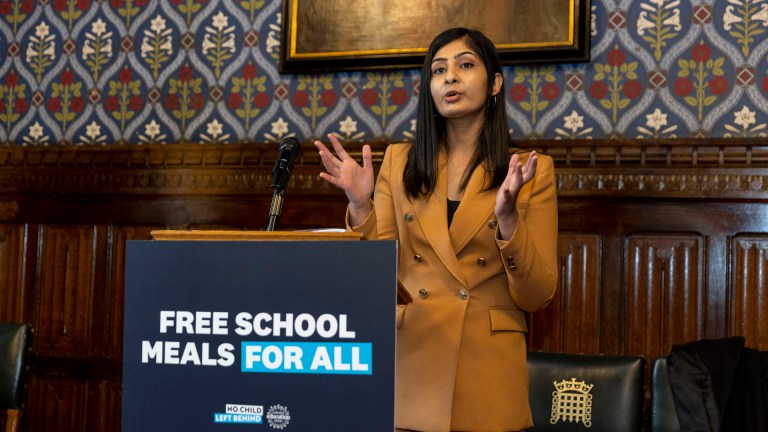 Zarah Sultana gives a speech standing behind a lectern with 