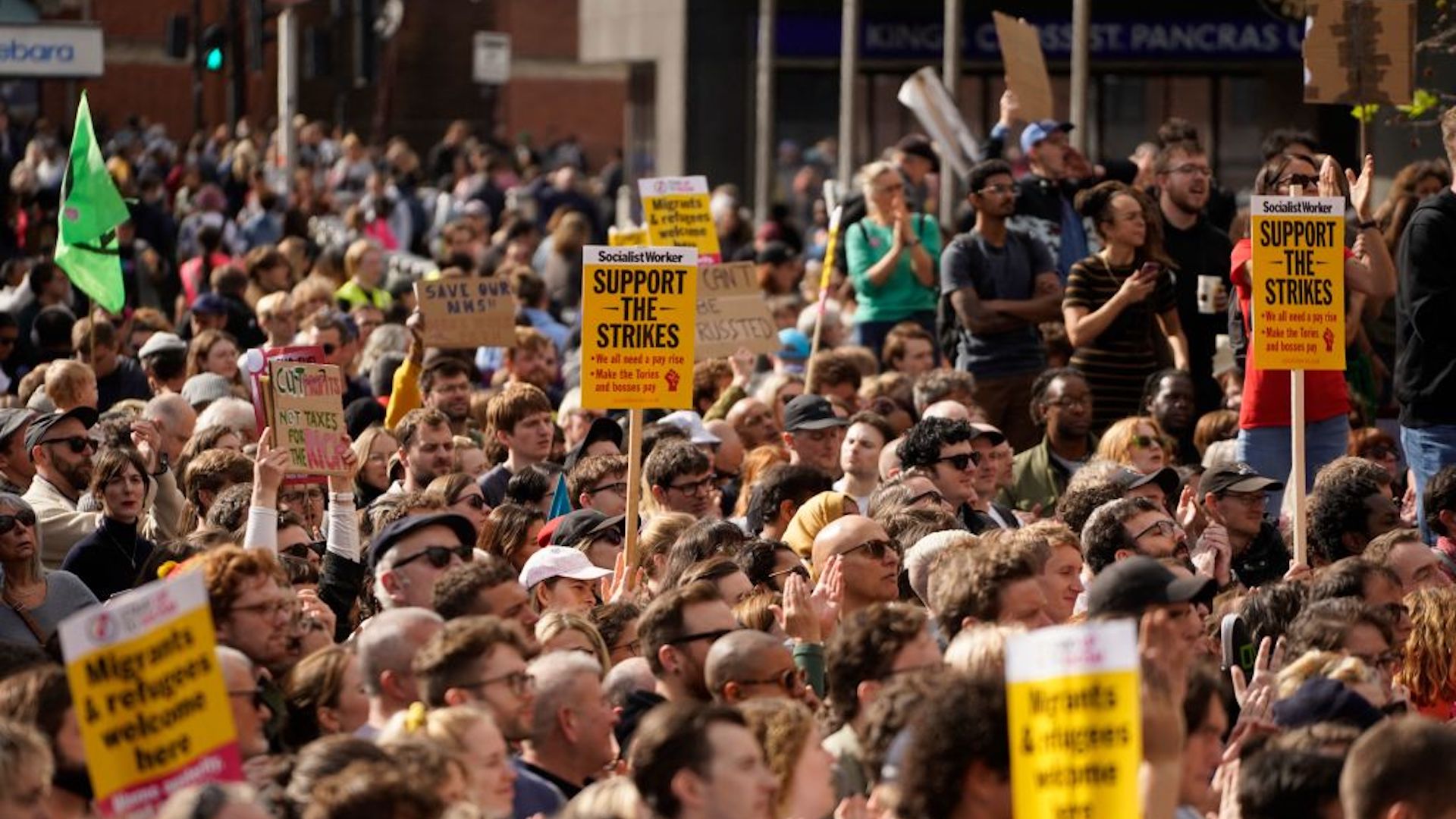 Protesters hold up flags and placards at a protest in London on October 1, 2022.