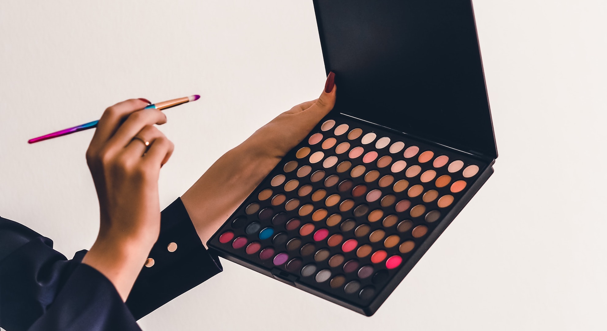 girl holding eyeshadow brush and eyeshadow palette