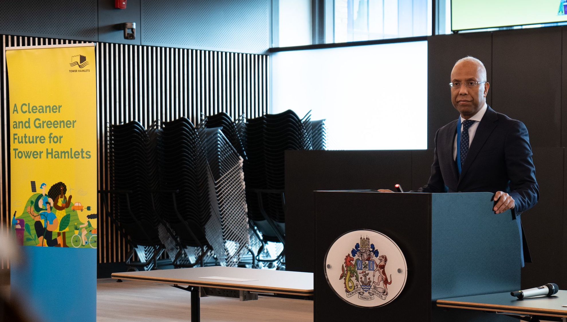 Mayor Luftur Rahman speaking at a lectern in Tower Hamlets town hall