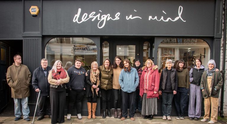 Staff, volunteers, and members standing outside Design in Mind studio