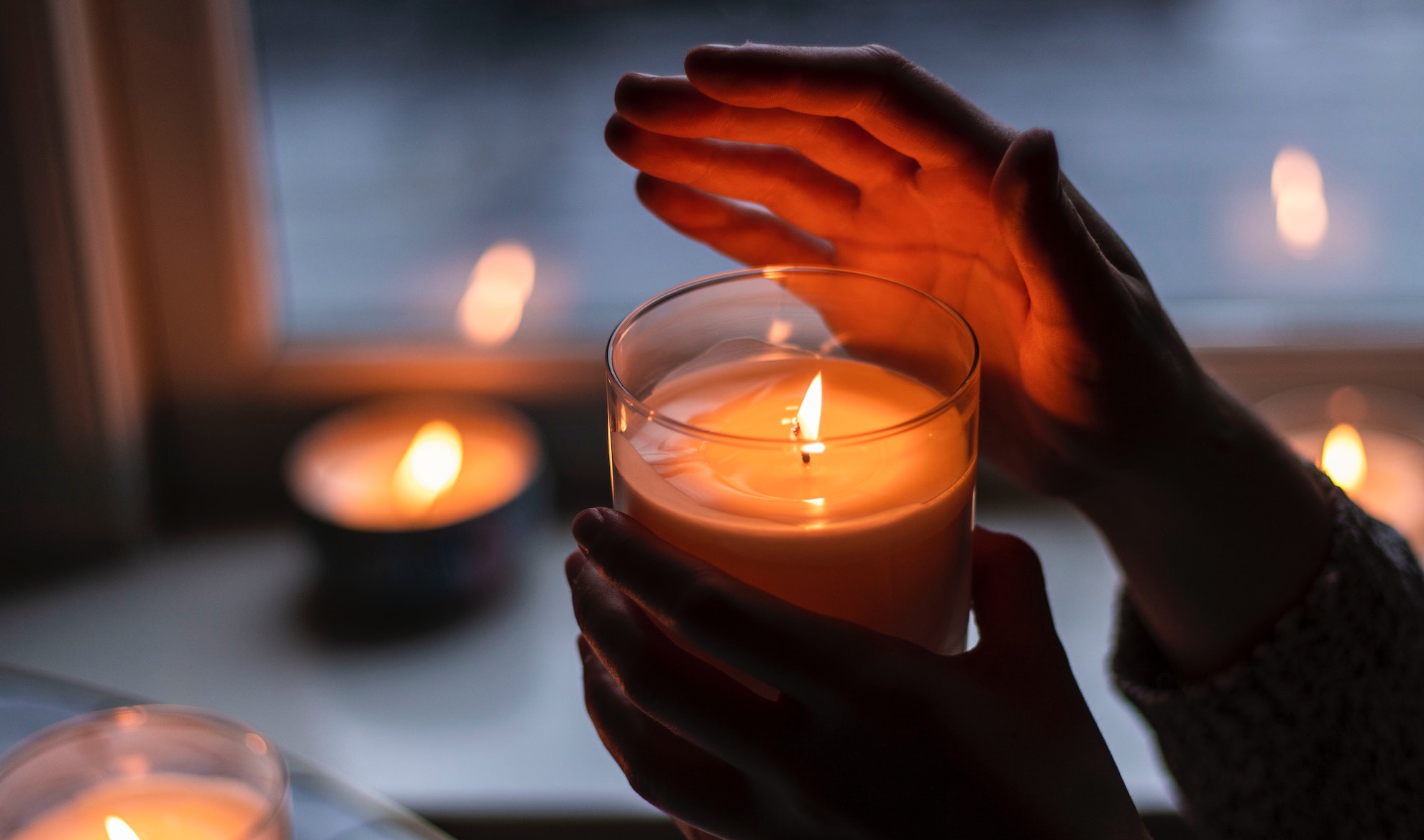 hands holding a lit candle