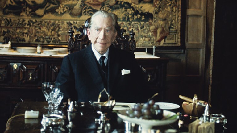 J Paul Getty sits at a dining table alone