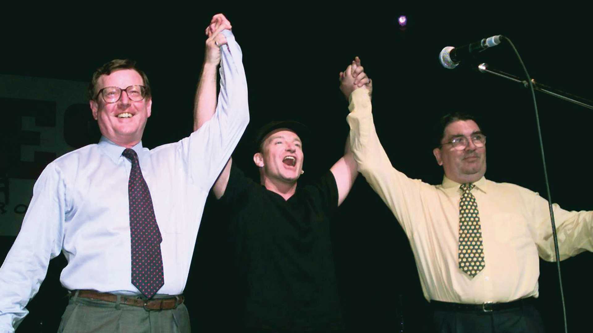 U2’s Bono backs the Good Friday Agreement with David Trimble and John Hume at the ‘Yes’ concert at Belfast Waterfront Hall, Northern Ireland, May 18, 1998. Image: Gerry Penny / Shutterstock