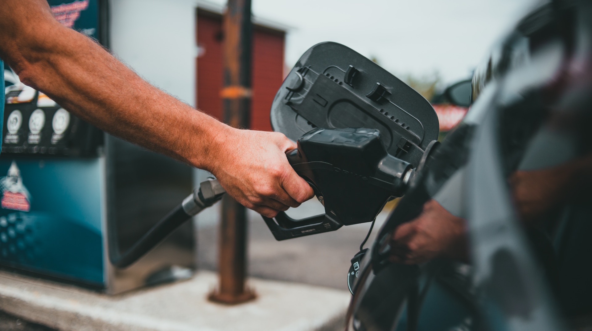 man putting petrol into car