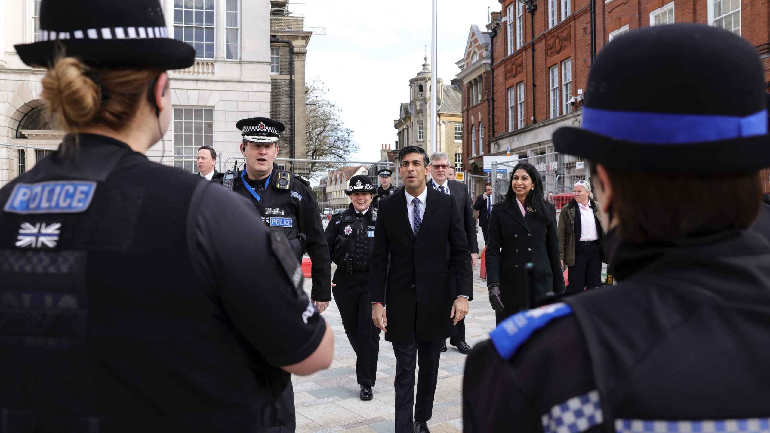 Prime Minister Rishi Sunak walks with Police Officers through Chelmsford high street to highlight government policy on Anti Social Behaviour looking toward 2 police officers in the foreground