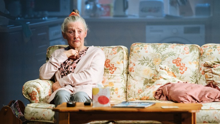Actress Bríd Brennan (Mary) sits on the sofa in Dixon and Daughters at the National Theatre.