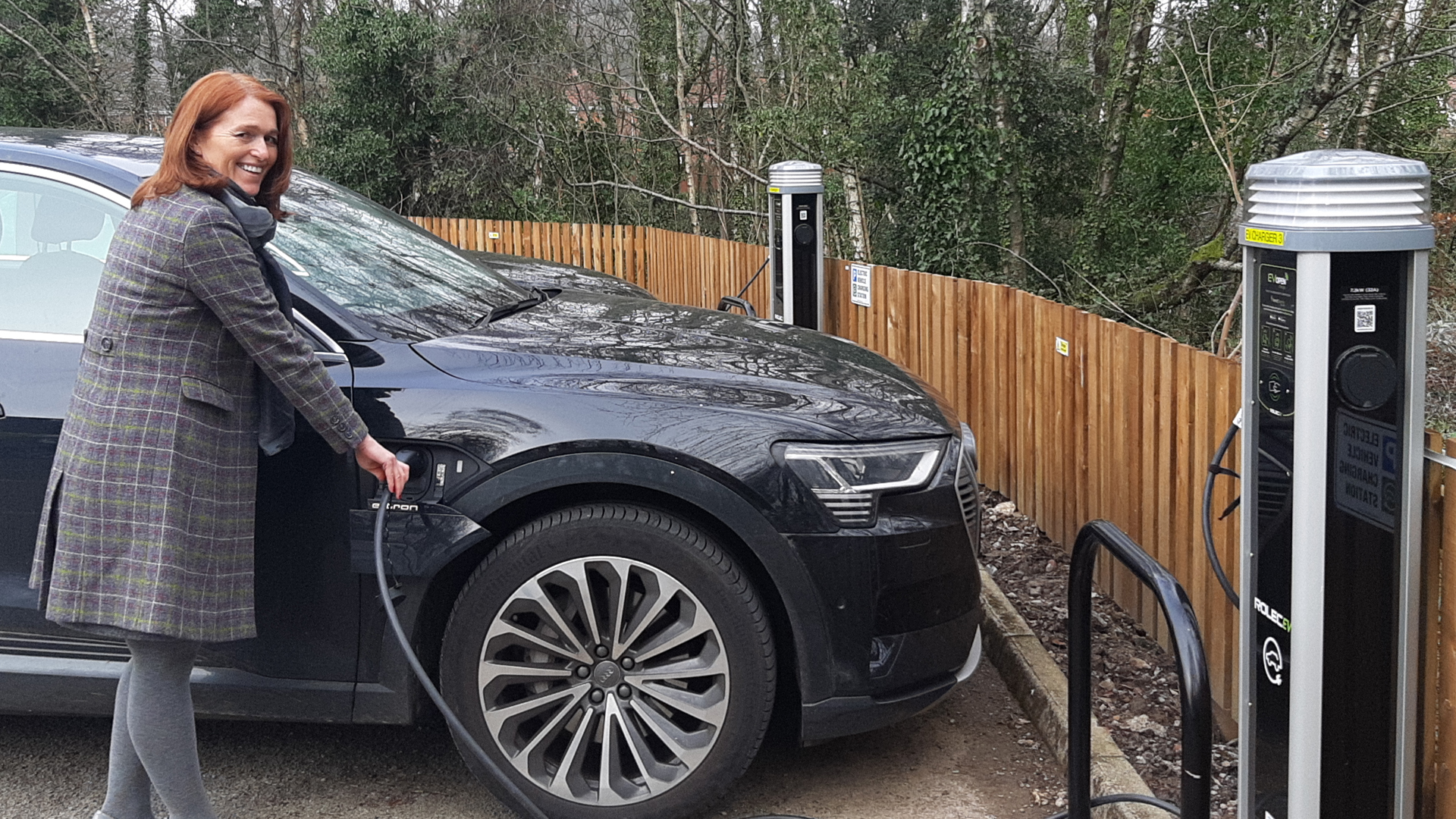 A woman charges an electric car