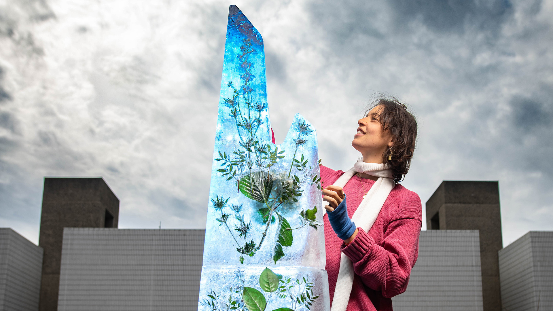 A woman stands beside the ice sculpture