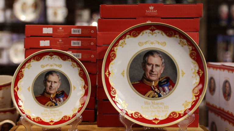 A photo of King Charles sits in the middle of a red, white and gold porcelain plate on display for the King's coronation