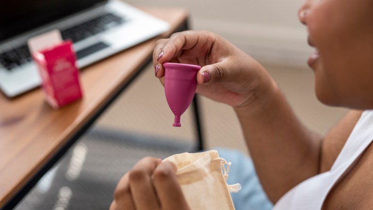 Woman taking a menstrual cup out of the bag.