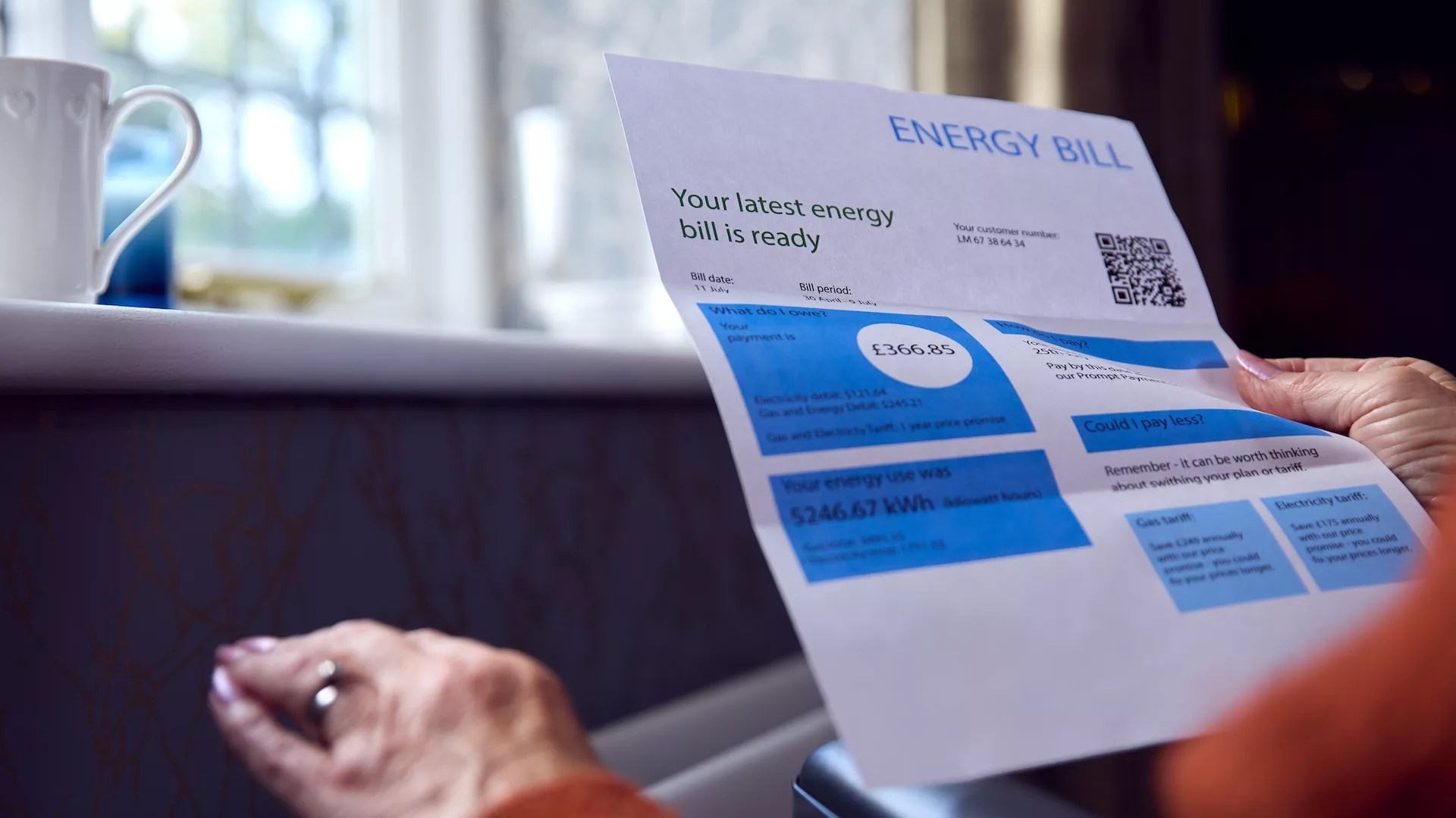 Close Up Of Senior Woman In Wheelchair With Energy Bill By Radiator In Cost Of Living Energy Crisis