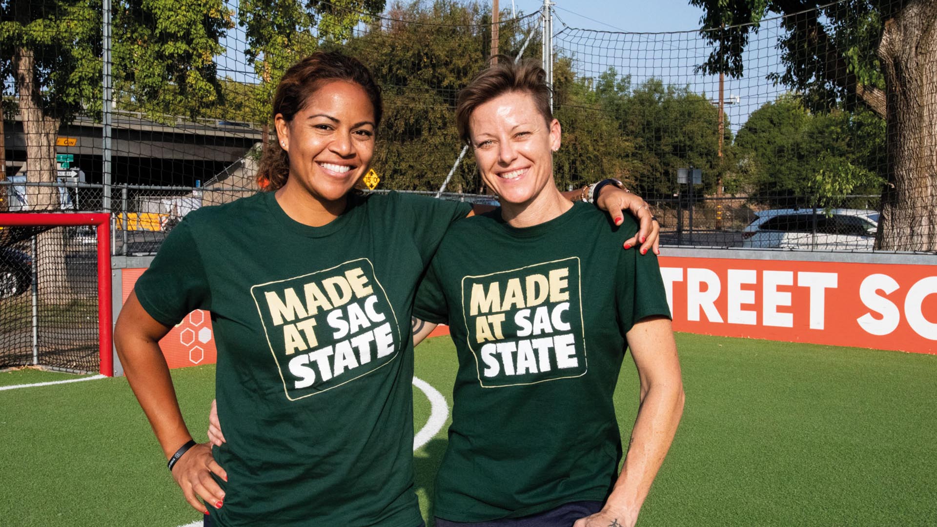 Lisa Wrightson and her team mate Tiffany Fraser stand with their arms around each other, wearing Tshirts saying 'made at Sac state'