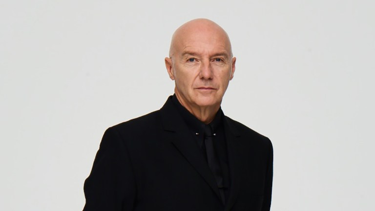 Midge Ure in a black shirt against a white background