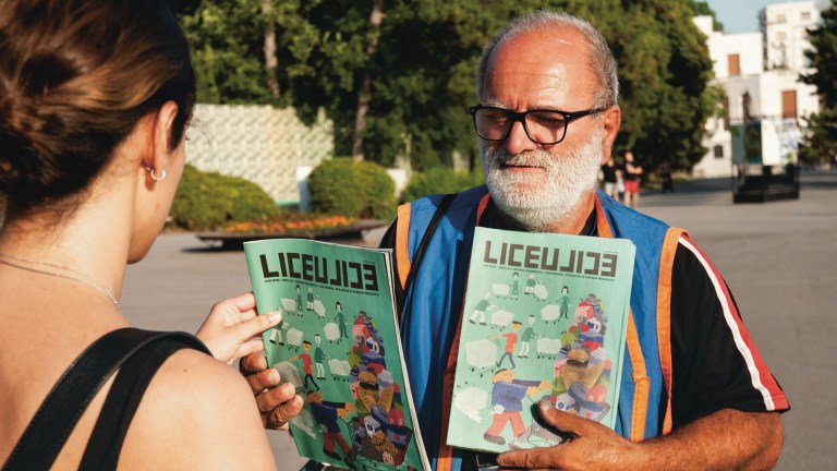 A street paper vendor in Belgrade makes a sale