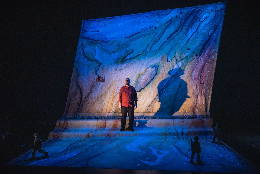 Itai Erdal standing on stage in his play about being in the Israel army