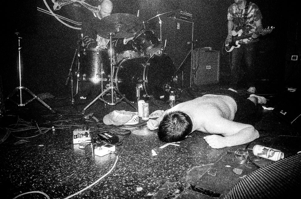 Chat Pile singer Raygun Busch lies on his face on stage, during one of their shows. 